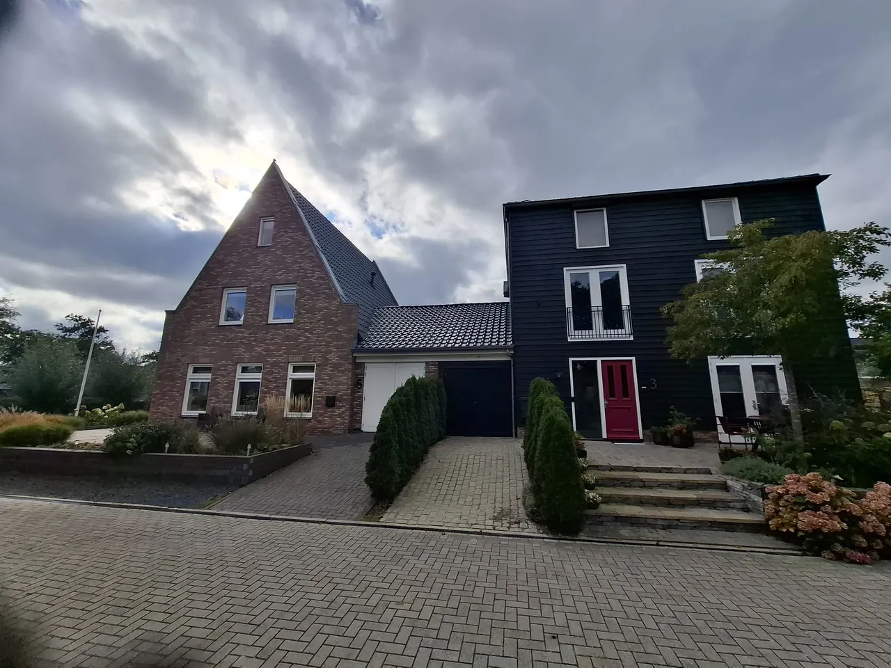 Twee woningen aan de straat in de omgeving van Wyldehoarne, een met baksteen en een met donker hout